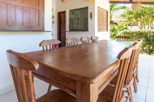 Pousada Villa Martins في ساو ميجيل دو غوستوسو: غرفة طعام مع طاولة وكراسي خشبية