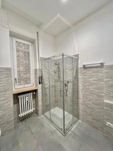 y baño con ducha y puerta de cristal. en Alloggio TOBIA en Biella