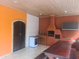 una cucina con pareti arancioni e soffitto in legno di Recanto do Valdir ad Angra dos Reis