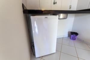 a small white refrigerator in the corner of a kitchen at Pousada Villa Martins in São Miguel do Gostoso