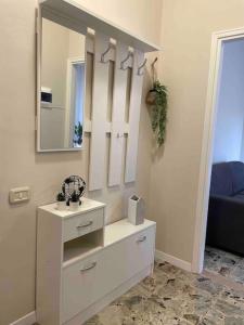 a white dresser with a mirror and a sink at Venere Apartment in Bergamo