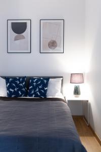 B&M - By The Sea Apartments Batorego 7 في غدينيا: غرفة نوم بسرير مع صورتين على الحائط