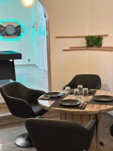 a table with chairs and a table with glasses on it at Le Cosy'ppart - EasyLife in Bourgoin
