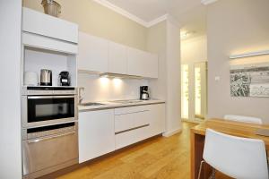 a kitchen with white appliances and a wooden table at Villa Rheingold - Lohengrin Wohnung 2 in Kühlungsborn