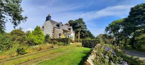 una vecchia casa con una statua in cima di Glenterry Farmhouse a Kirkcudbright