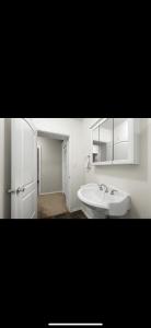 Baño blanco con lavabo y espejo en Verona Beach House, 
