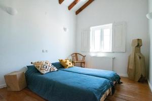 une chambre avec un lit avec des draps bleus et une fenêtre dans l'établissement Casa Litoral, à Melides 31 autres photos