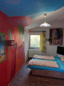 ブラチスラヴァにあるHotel Galéria pre sebarozvoj - pobytová galéria sebarozvojaのベッドルーム1室(ベッド1台付)が備わります。壁には絵画が飾られています。
