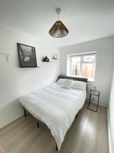 a white bed in a room with a window at Retro 3 bed, 2 En-suite Haven in Birmingham