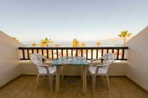 una mesa y sillas en un balcón con vistas al océano en Parque Santiago II 379 Tenerife Rental and Sales, en Playa de las Américas