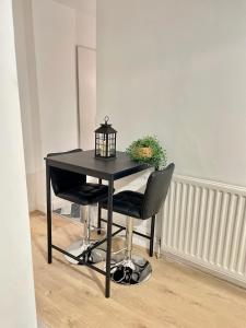 a black table with two chairs and a lamp at Retro 3 bed, 2 En-suite Haven in Birmingham