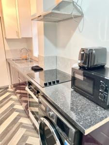 a kitchen with a counter with a microwave on it at Retro 3 bed, 2 En-suite Haven in Birmingham