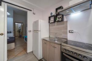 een keuken met een witte koelkast en een wastafel bij Luna Rossa in Giardini Naxos