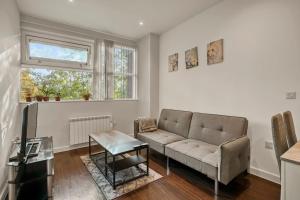 a living room with a couch and a table at Chic 1 Bedroom Apartment in London