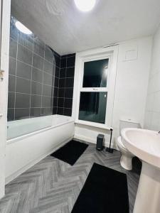 a bathroom with a sink and a toilet and a window at Vinery Green Long Stay Offers in Knowsthorpe