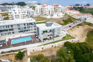 een luchtfoto van een gebouw met een zwembad bij Panoramic Views - Terrace, Sea Views & Pool in Nazaré