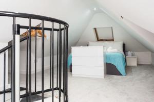 a attic bedroom with a bed and a staircase at The White Cottage at Gildridge + Private Hot Tub+EV in Chiddingly