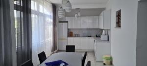 a kitchen with white cabinets and a table with chairs at Apartments Dinko in Novalja