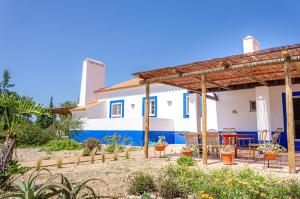 une terrasse avec des tables et des chaises en face d'une maison dans l'établissement Casa Litoral, à Melides