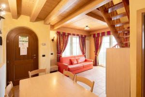 a dining room with a table and a red chair at Chalet Li Palù Trilocale 4 in Livigno