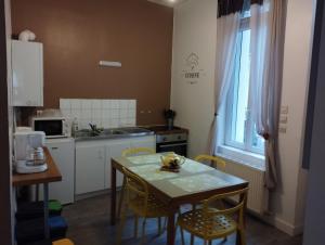uma cozinha com uma mesa e cadeiras e uma cozinha com uma janela em Le Grèbe em Le Tréport