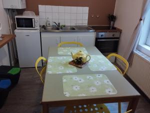 uma cozinha com uma mesa com cadeiras e um bule de chá em Le Grèbe em Le Tréport