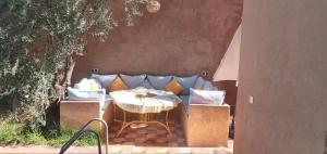 a table and chairs with a couch in a courtyard at Villa Korima in Marrakesh