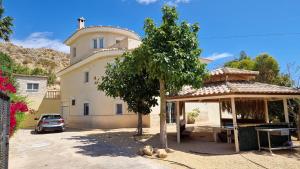 a large house with a tree in front of it at Casa Gran Mirador - Ruime vakantie villa met groot privé zwembad 8-14 pers in Alicante