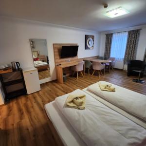 um quarto de hotel com duas camas e uma sala de jantar em Posthotel Traube em Donauwörth