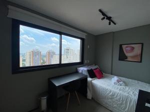 a bedroom with a bed and a desk and a window at Studio Vl Mariana-ao lado Facul ESPM in Sao Paulo