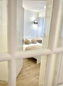 a small white room with a bed and a mirror at T2 Hyper centre 3 étoiles Rue du Casino in Aix-les-Bains