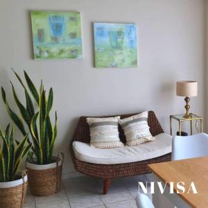 a living room with a wicker couch and two plants at Edificio NIVISA in Posadas