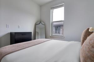 a white bedroom with a bed and a window at Downtown 1br w deck gym nr Congress Ave ATX-216 in Austin