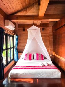 a bed in a room with a canopy over it at Baan Laanta Resort & Spa - SHA PLUS in Ko Lanta
