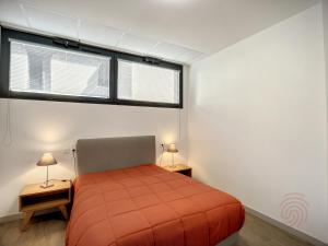 um quarto com uma cama laranja e 2 candeeiros em Appartement Lamalou-les-Bains, 3 pièces, 4 personnes - FR-1-451-170 em Lamalou-les-Bains