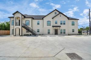 a large house with a staircase in a driveway at TEXAS-Style 2 BR Apartment near NRG Stadium, University of Houston, Med Center, Gated, Wifi, Parking in Houston