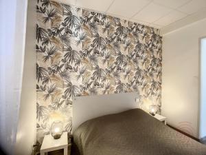 sypialnia z łóżkiem z czarno-białą tapetą w obiekcie Appartement F3 avec Terrasse, Proche Centre et Thermes, Animaux Acceptés - Lamalou-les-Bains - FR-1-451-174 w mieście Lamalou-les-Bains