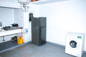 een keuken met een koelkast en een wasmachine bij The White Villa in Hikkaduwa
