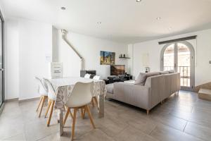 a living room with a table and a couch at Townhouse Calvari By homevillas360 in Pollença