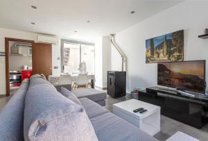 uma sala de estar com um sofá e uma televisão em Townhouse Calvari By homevillas360 em Pollença