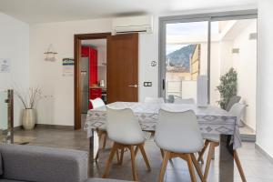 uma sala de jantar com uma mesa e cadeiras brancas em Townhouse Calvari By homevillas360 em Pollença