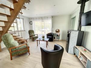 ein großes Wohnzimmer mit Stühlen und einem TV in der Unterkunft Maison Jullouville, 3 pièces, 6 personnes - FR-1-361-464 in Jullouville-les-Pins