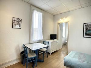Pokój z biurkiem, łóżkiem i stołem w obiekcie Studio cosy proche des Thermes, centre-ville et nature, WiFi, animaux acceptés - FR-1-451-181 w mieście Lamalou-les-Bains
