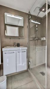 Un baño con ducha, lavabo y espejo. en Les Restanques Cabrière 3123 vue mer 3 chambres, en Grimaud
