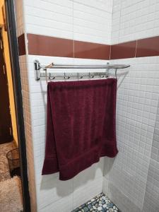 un bagno con un asciugamano bordeaux sullo scaffale di Tastefully furnished apartment a Port Harcourt