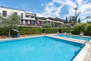 a swimming pool in front of a house at Blue Moon duepunto0 in Gardone Riviera