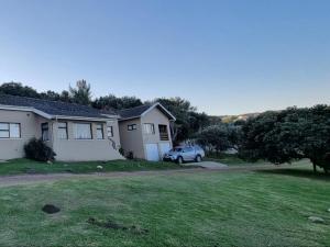 a house with a car parked in a yard at Stumble Inn in Haga-Haga