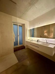 baño con 2 lavabos y ventana grande en Room in luxurious apartment, en Hamburgo