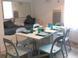 einen Tisch und Stühle im Wohnzimmer mit Sofa in der Unterkunft Appartement Blonville-sur-Mer, 2 pièces, 4 personnes - FR-1-712-31 in Blonville-sur-Mer