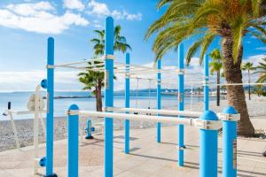 a playground on the beach with palm trees at Le Maeva in Saint-Laurent-du-Var